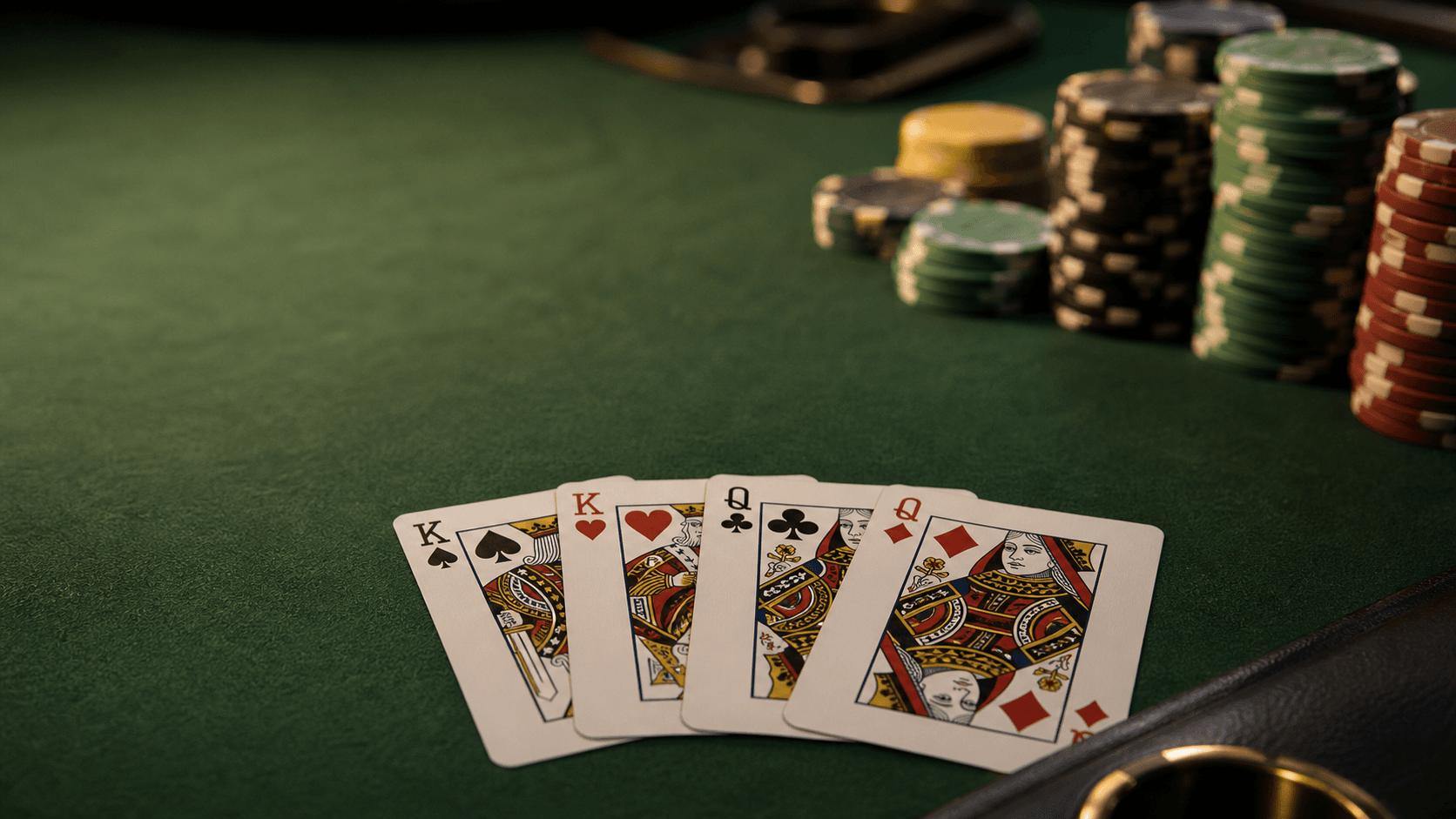 Two paired ranks show in a fanned Omaha hand beside chips on dark green felt.